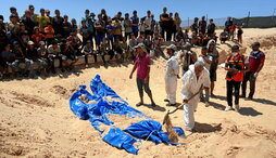 Varios hombres entierran los cuerpos robados y devueltos ayer por Israel durante un funeral masivo en un cementerio en Jan Yunis.