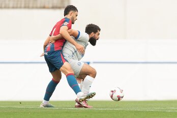 Asier Villalibre protege el balón ante un rival del Huesca.