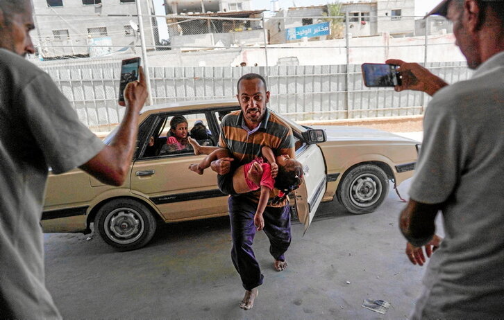 Un palestino lleva una niña herida en un ataque israelí, al hospital Nasser, en Jan Yunis.