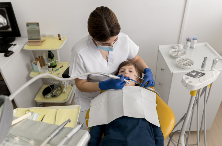 Un niño en la consulta de una dentista. 