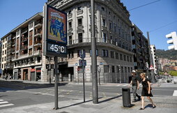 Una pareja camina junto a un termómetro que el domingo marcaba 45°C en Bilbo.