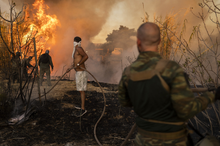 Voluntarios tratan de combatir el fuego en la zona de Penteli. 