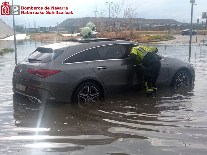 Los Bomberos recatan sin daños a 3 personas atrapadas en un vehículo inundado en Viana.