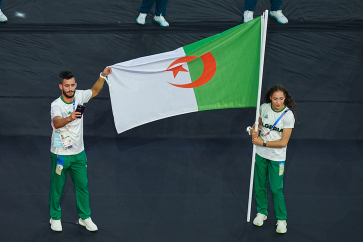 Imane Khelif, a la derecha, porta la bandera argelina en la ceremonia de clausura de los Juegos Olímpicos de París.