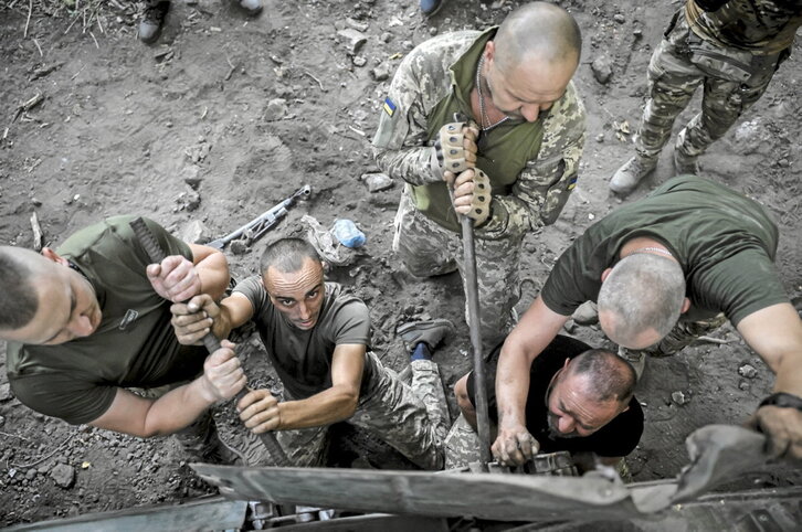 Mecánicos ucranianos se afanan en reparar un tanque en Donetsk.