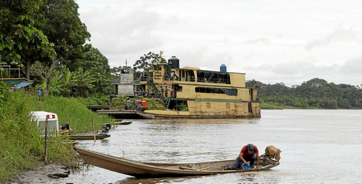 En el río Marañón, un aldeano en su canoa y un barco que transporta personas y mercancías como plátanos. 