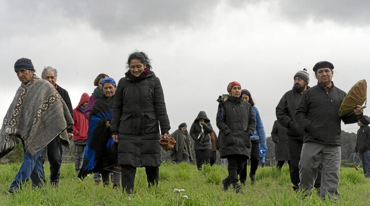 A la derecha, un grupo de personas mapuche camina por la pampa Koz Koz, en Panguipulli. A la izquierda, Trafkintu celebrado en la pampa de Koz Koz.