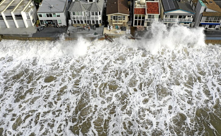 Las olas a punto de impactar contra viviendas en la costa de California, también amenazada por el aumento del nivel del mar.