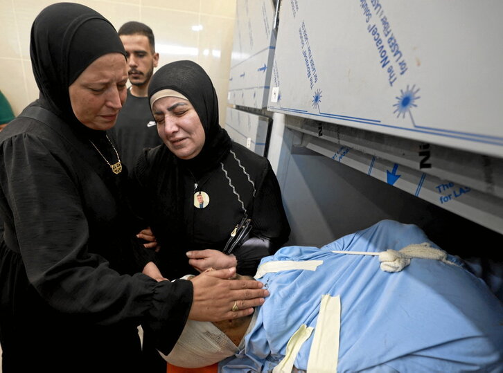 Mujeres palestinan lloran junto al cadáver de un familiar muerto en el ataque israelí en Nur Shams.