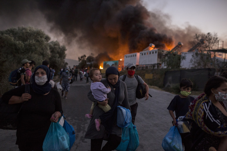 Personas refugiadas huyen del fuego en el campo de Moria.