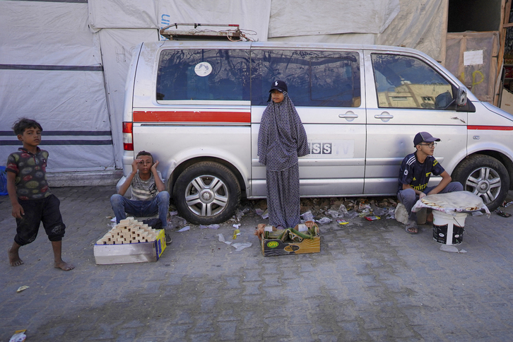 Varios niños venden productos en una calle de Jan Yunis, en el sur de la Franja de Gaza, en medio de la ofensiva militar israelí que está arrasando el asediado enclave.