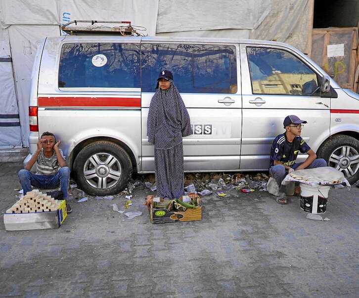 Varios niños venden productos en una calle de Jan Yunis, en el sur de la Franja de Gaza, en medio de la ofensiva militar israelí que está arrasando el asediado enclave.