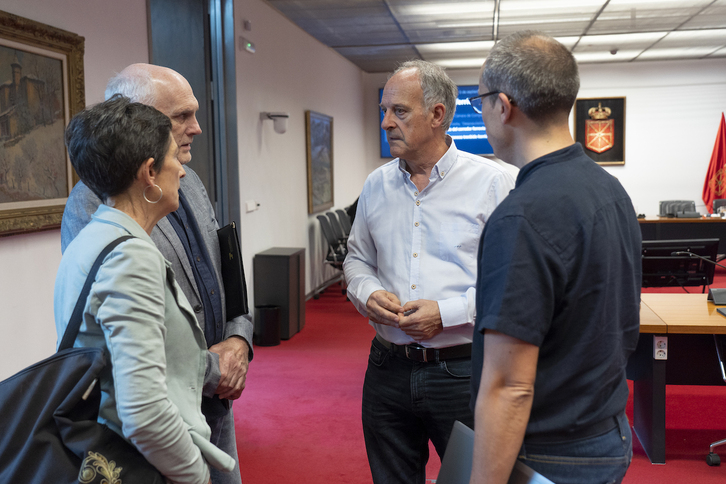 Los parlamentarios de EH Bildu Adolfo Araiz y Mikel Zabaleta conversan con dos integrantes de la plataforma Salvemos Iza-Gulina Bizirik en el Parlamento navarro.