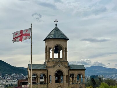 Georgiako bandera bat eliza baten aurrean, Tbilisin.