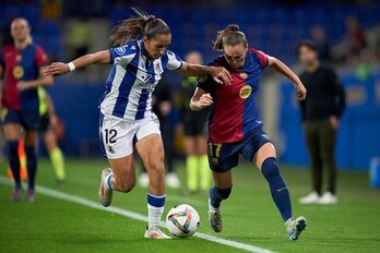 Lucía y Pajor pugnan por el balón junto a la línea de banda.