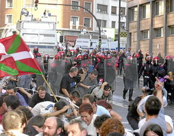 Efectivos de la Ertzaintza, apoyados por una tanqueta, durante la carga contra los manifestantes.