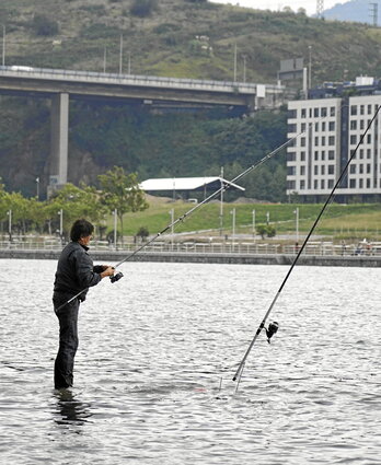 A la izquierda, un pescador en la Ría del Ibaizabal a la altura de Erandio; a la derecha, el oleaje golpea el malecón de Zarautz.