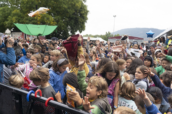 La chavalería se ha congregado ante el escenario para recoger los caramelos.