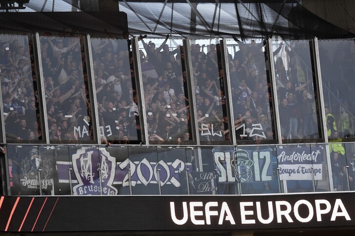 Los hinchas del Anderlecht, en la grada protegida por una manpara que algunos de ellos agujerearon para arrojar las sillas.