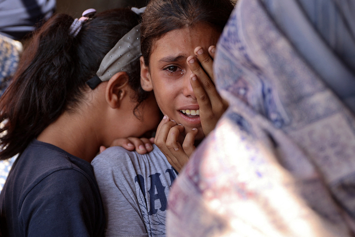 Niñas palestinas lloran y se consuelan tras un ataque de cazas israelíes contra un refugio en Falluja este septiembre.