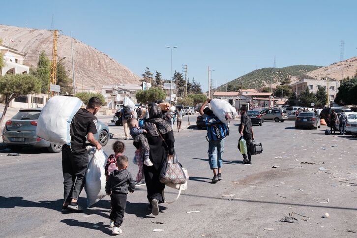 Personas desplazadas cruzan el paso fronterizo de Masnaa, desde Líbano hacia Siria.