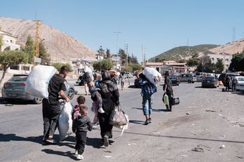 Personas desplazadas cruzan el paso fronterizo de Masnaa, desde Líbano hacia Siria.