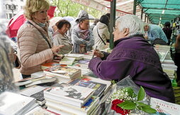 Toti Martínez de Lezea atiende a una lectora en la feria del libro que se celebró en abril en Bilbo.