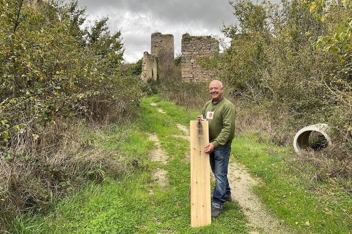 Toni Agudo posa ante las ruinas de Mendinueta con la rampa desde la que lanza los cohetes para anunciar las fiestas del pueblo deshabitado.