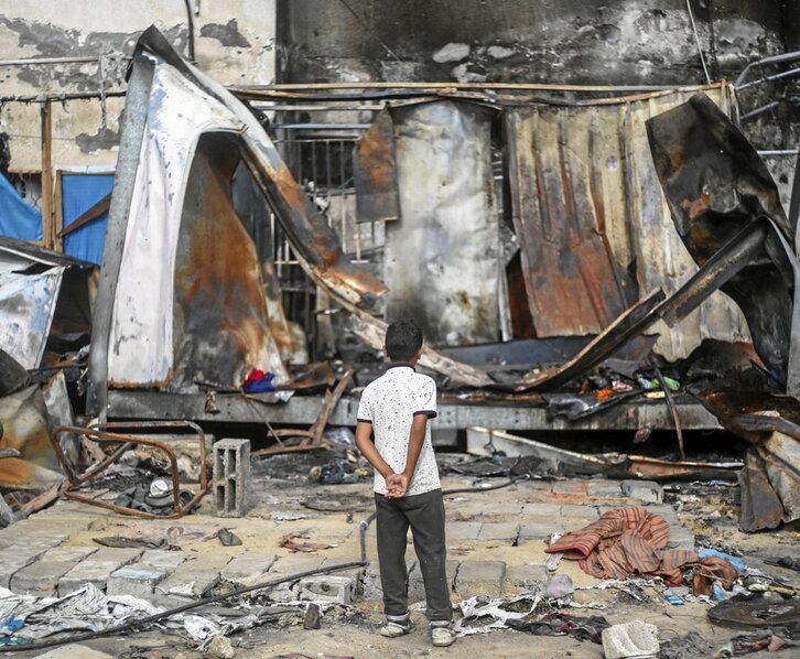 Un niño palestino observa los restos calcinados del campamento del hospital Al Aqsa.