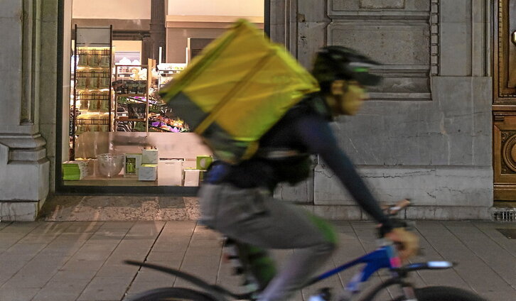 Un operario reparte comida montado en una bicicleta, una imagen que se ha convertido en algo habitual sobre todo en las grandes ciudades.