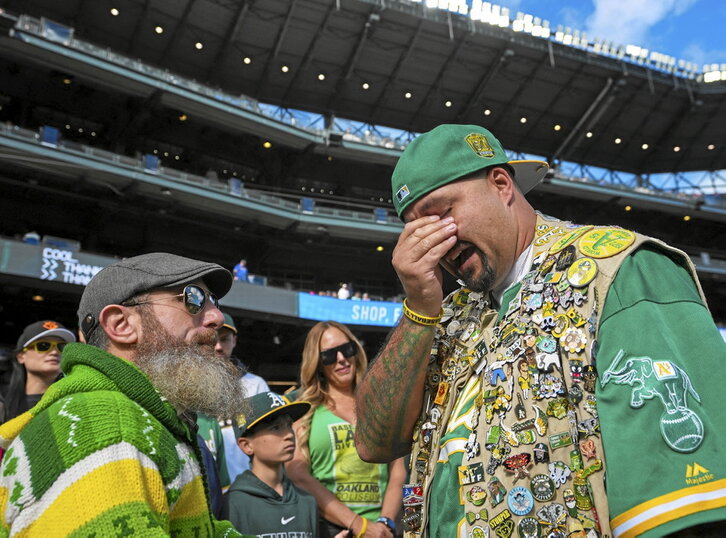 Un aficionado de Oakland A's llora frente al jugador Dallas Braden antes de comenzar el partido contra Seattle Mariners.