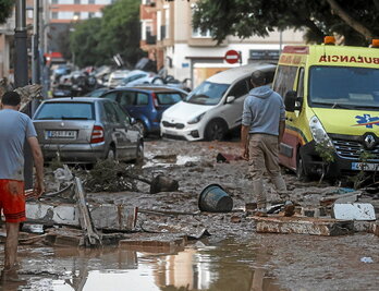 Coches apilados y barro en una calle de Alfafar, en Valencia.