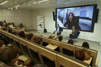 Lourdes Pérez Rebollar (en la pantalla) habló de su experiencia con el alzhéimer con Gurutz Linazasoro, Lourdes Ubetagoyena y el público de la sede del Colegio de Médicos de Gipuzkoa.