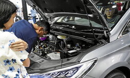 Un visitante estudia la ingeniería de un BYD M8 en la feria de Bangkok de esta semana.