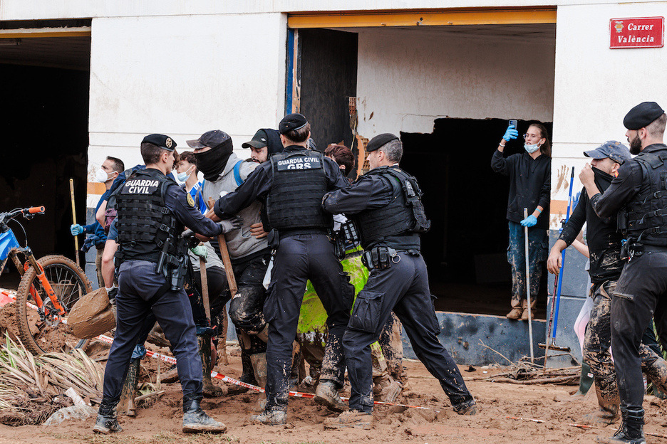 Guardia civiles tratan de contener a vecinos que protestan.