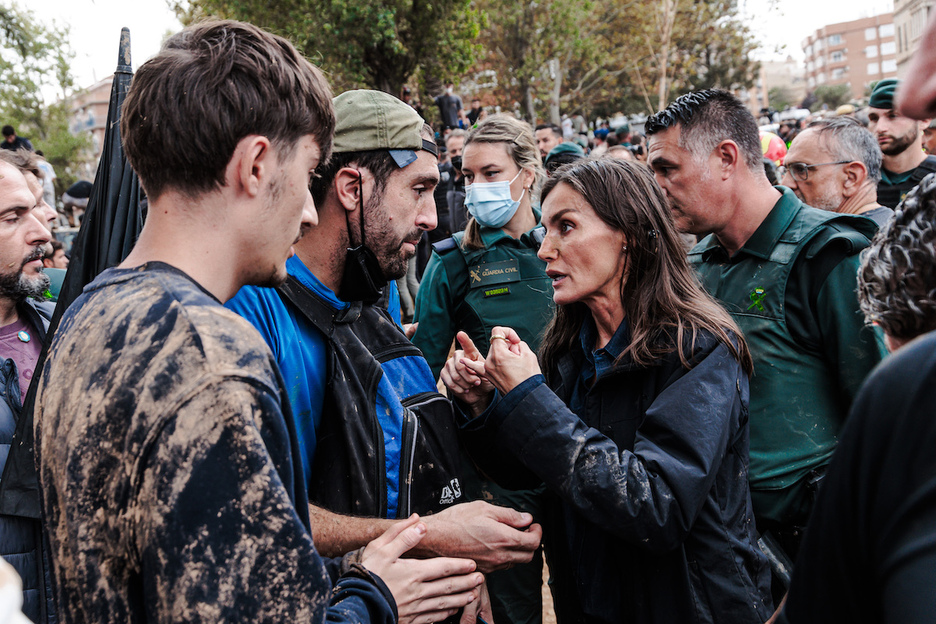 Letizia Ortiz, con cara descompuesta, trata de responder a unos vecinos indignados.