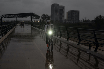 Un ciclista circula bajo la lluvia en València.