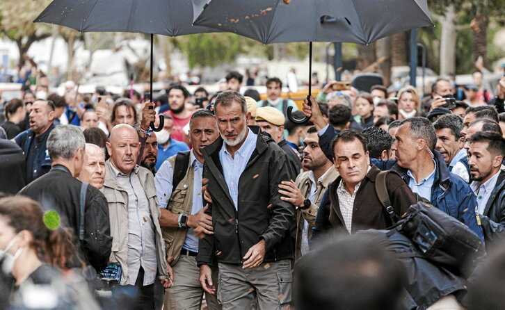 Escoltas protegen con paraguas a Felipe de Borbón del barro que le arrojaron los vecinos de Paiporta.