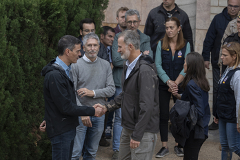 Felipe de Borbón saluda al presidente del Gobierno español, Pedro Sánchez, durante su visita al centro del 112 en Valencia, en presencia del ministro de Interior.