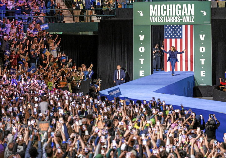 En la página anterior, Kamala Harris se dispone a intervenir, el domingo, en el mitin celebrado en Michigan. Sobre estas líneas, una familia vota anticipadamente en Seattle.