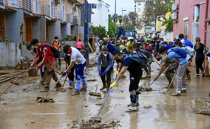 Voluntarios limpian la calle en el municipio de Alfafar.