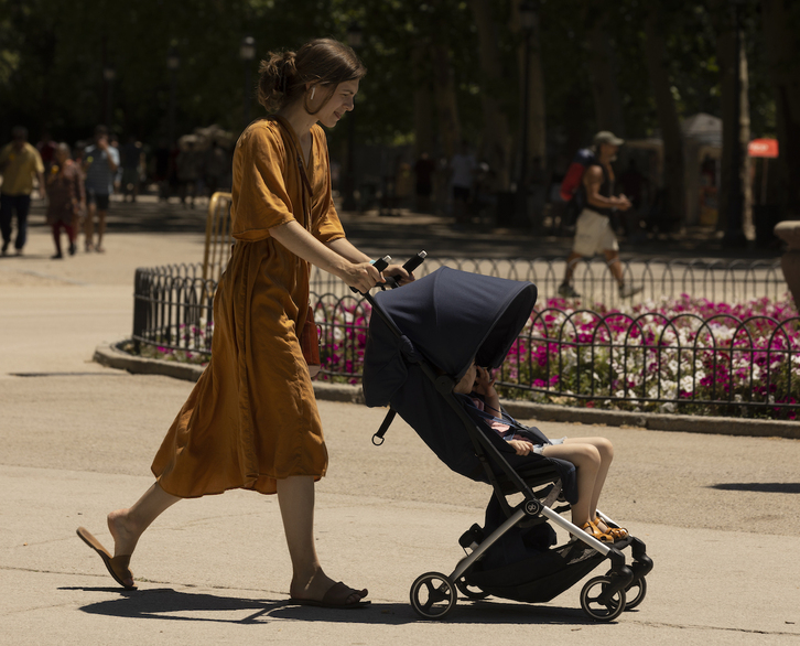 Una madre pasea con su hijo en Madrid.