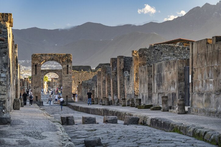 Varias personas visitan la antigua ciudad romana.