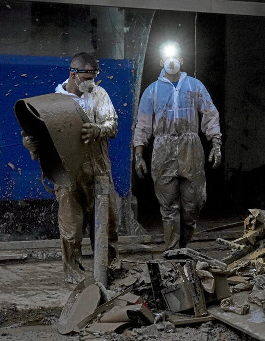 Dos voluntarios limpian de noche los estragos de la DANA en Benetússer.