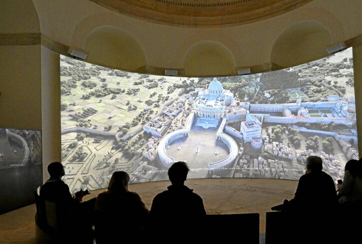 Una pantalla gigante muestra en el Vaticano vídeos sobre la construcción de la basílica.