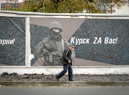 Un hombre pasa ante un mural en honor de los soldados rusos, en Kursk.