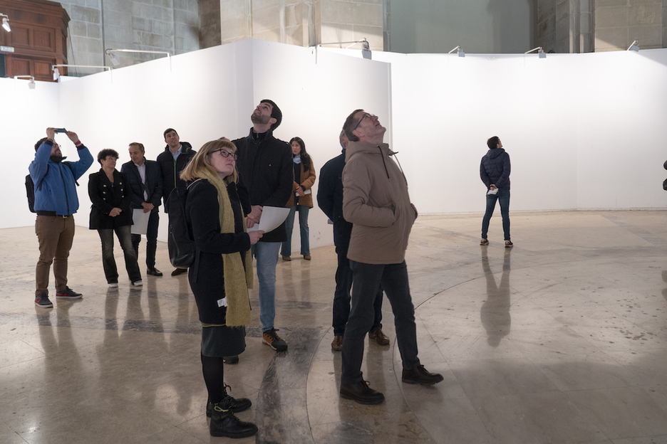 Parlamentarios miran las pinturas de la cúpula desde la nave principal.