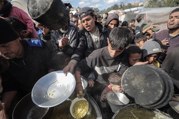 Desplazados gazaties intentar recibir comida.