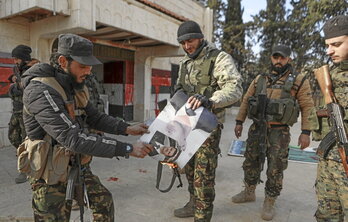 Yihadistas del grupo Hayat Tahrir al-Sham queman una foto del presidente sirio en el área de  Zarbah, al norte de Alepo.