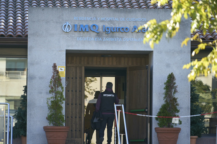 Un ertzaina en la entrada a la residencia en la que se produjo la muerte violenta.